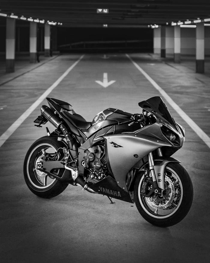 Stylish black and white shot of a sleek sports motorcycle in an empty parking garage.